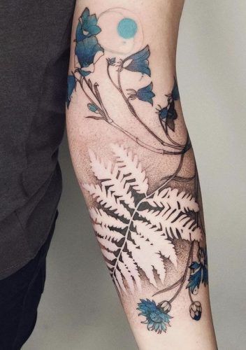 Tattoo mit Blumen und Farn mit blauen Akzenten